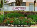 Community sign reading 'LeClare Shores,' a deed-restricted community, surrounded by colorful flower beds at 5110 Corvette Dr, Tampa, FL 33624