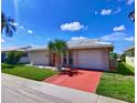 Delightful single-story home with a red driveway, green lawn, and a decorative palm tree at 5390 Magnolia N Trl, Pinellas Park, FL 33782