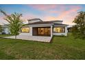 A patio with a screen overlooks a manicured lawn and a tranquil lake at 8612 Ivy Stark Blvd, Wesley Chapel, FL 33545