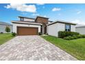 Charming two-story home with brick driveway, beautiful stone accents, and a manicured lawn at 8612 Ivy Stark Blvd, Wesley Chapel, FL 33545