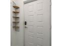 Entryway featuring a white paneled door and decorative wooden shelves at 9660 Tara Cay Ct # 38, Seminole, FL 33776