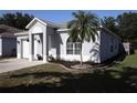 Well-maintained single-story home with gray paint, an arched window, a single-car garage and a landscaped front yard at 1006 Harvest Moon Dr, Seffner, FL 33584