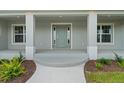 Close up of the front door with sidelights, columns, and manicured landscaping at 10237 Deerwood Ave, Englewood, FL 34224
