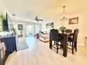 Bright living room with light wood floors, a ceiling fan, and access to an outdoor space at 10636 Millriver Dr, New Port Richey, FL 34654