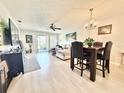 Bright living room with light wood floors, a ceiling fan, and access to an outdoor space at 10636 Millriver Dr, New Port Richey, FL 34654