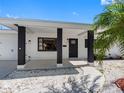 Inviting front entrance with dark pillars, white rock landscaping, and sidewalk to the driveway at 1154 64Th S Ave, St Petersburg, FL 33705