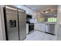 Modern kitchen with stainless steel appliances, white cabinets, and tile backsplash at 1247 Kennewick Ct, Wesley Chapel, FL 33543