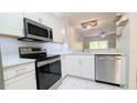 Bright kitchen featuring stainless steel appliances, stylish backsplash and tiled floors at 1247 Kennewick Ct, Wesley Chapel, FL 33543