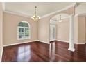 Open dining area with rich hardwood floors, elegant lighting, and a large arched window at 13321 Lewis Raulerson Rd, Dover, FL 33527