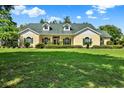 Beautiful single-Gathering home with a large front yard, manicured landscaping, and charming curb appeal at 13321 Lewis Raulerson Rd, Dover, FL 33527