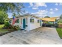 Single-story home featuring a covered parking area and a well-maintained white exterior with blue accents at 1529 Essex N Dr, St Petersburg, FL 33710
