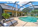Relaxing screened-in pool area with lounge chairs on a sunny day at 1649 Ledgestone Dr, Brandon, FL 33511