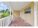 Spacious covered porch featuring tile flooring, white railings, and a view of the surrounding landscape at 2333 Indigo Dr, Clearwater, FL 33763