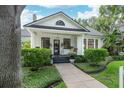 A charming home with manicured bushes and green lawn leads to a welcoming porch, all under a bright sky at 2412 W Prospect Rd, Tampa, FL 33629