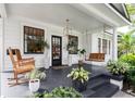 Inviting front porch with rocking chairs and a porch swing, perfect for relaxation and enjoying the outdoors at 2412 W Prospect Rd, Tampa, FL 33629