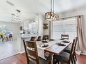 Open concept dining room features hardwood floors and modern lighting fixtures above the table at 24811 Gun Smoke Dr, Land O Lakes, FL 34639