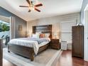 Cozy main bedroom features shiplap wall, a large bed, and access to a private outdoor patio at 24811 Gun Smoke Dr, Land O Lakes, FL 34639