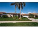 Beautiful single-story home featuring a tile roof, arched doorway, and a well manicured lawn at 2691 Saddlewood Ln, Palm Harbor, FL 34685