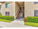 Exterior of a well-maintained condo building featuring tidy landscaping and a staircase leading to the upper units at 4215 E Bay Dr # 1706A, Clearwater, FL 33764