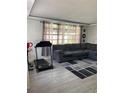 Cozy living room featuring a large sectional sofa, modern rug, and exercise equipment at 4219 Gray Squirrel Ln, New Port Richey, FL 34653