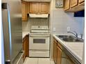 Efficient kitchen design with white appliances and tile backsplash at 4712 Marine Pkwy # 203, New Port Richey, FL 34652