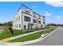 Stylish townhouse featuring a contemporary design, well-maintained landscaping, and black metal fencing at 6206 64Th N Way, Pinellas Park, FL 33781