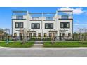 Modern townhouse with rooftop terrace, showcasing sleek design and a cozy front yard with decorative accents at 6206 64Th N Way, Pinellas Park, FL 33781