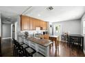 Open kitchen with granite countertops, wooden cabinets, stainless steel appliances, and breakfast bar at 6212 S Adelia Ave, Tampa, FL 33616