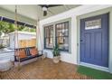 Inviting front porch featuring stylish flooring, comfortable swing, and updated exterior at 650 63Rd S Ave, St Petersburg, FL 33705
