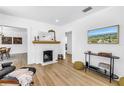 Open living room with hardwood flooring, white brick fireplace and an abundance of natural light at 650 63Rd S Ave, St Petersburg, FL 33705