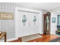 Elegant double front door opening into a foyer with hardwood floors and decorative wallpaper at 6505 Cedar Ne St, St Petersburg, FL 33702