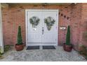 Double front doors accented with wreaths and potted topiaries in front of a brick facade at 6505 Cedar Ne St, St Petersburg, FL 33702