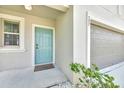 Close-up of a charming home's light blue front door and two-car garage at 797 Olive Conch St, Ruskin, FL 33570