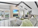 Bright living room features vaulted ceilings with exposed beams, stylish decor, and an electric fireplace at 8010 W Hiawatha St, Tampa, FL 33615