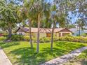 A charming home enhanced by mature trees and lush green grass in a desirable neighborhood at 8405 Woodbridge Blvd, Tampa, FL 33615