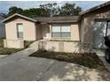 Tan single story home featuring a driveway and a concrete walkway to the front door at 8801 Orange Blossom Dr, Seminole, FL 33772