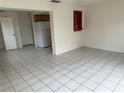 View of the living room featuring white tile floors with the kitchen in the background at 8801 Orange Blossom Dr, Seminole, FL 33772