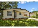 Inviting home featuring a carport, well-maintained lawn, and fresh exterior paint at 9312 N Tampa St, Tampa, FL 33612