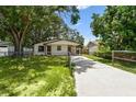 This attractive single-story home has a long driveway, carport, and a well-maintained front lawn at 9312 N Tampa St, Tampa, FL 33612