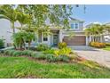 Inviting home featuring a paver driveway, beautiful flower beds, and manicured landscaping at 12121 Rustic River Way, Tampa, FL 33635
