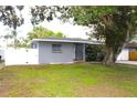 A quaint single-story home featuring a gated fence and green lawn at 1317 S Betty Ln, Clearwater, FL 33756