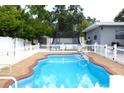 Inviting backyard pool, perfect for relaxation and entertainment, with a white fence and brick trim at 1317 S Betty Ln, Clearwater, FL 33756