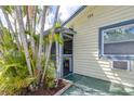 A screened porch, framed by palm trees, offers a private entrance to the home's facade at 153 Alpine Ct, Bradenton, FL 34208