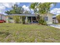 A cozy single-story house with a lush lawn, complemented by lovely landscaping at 153 Alpine Ct, Bradenton, FL 34208