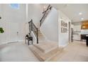 Bright foyer features a staircase with iron railings and views into the kitchen area at 18144 Frame Bnd, Land O Lakes, FL 34638