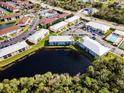 Aerial view of the community with a central pond, mature trees, amenities, and ample parking at 25050 Sandhill Blvd # 8B1, Punta Gorda, FL 33983