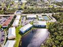 This aerial showcases the pool, tennis court, and lake views in this well-maintained community at 25050 Sandhill Blvd # 8B1, Punta Gorda, FL 33983