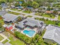 Stunning aerial view of backyard featuring a kidney-shaped pool, sunny lounge area, privacy fence, and a detached shed at 2581 61St S Ave, St Petersburg, FL 33712