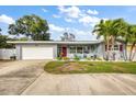Inviting single-story home featuring a red front door and a well-maintained lawn at 3173 Fountainhead Dr, Largo, FL 33770