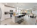 Open-concept kitchen with stainless steel appliances, granite countertops, island, and breakfast bar at 39024 Harlow Rose Dr, Zephyrhills, FL 33540